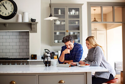 Couple looking at a laptop in the kitchen
