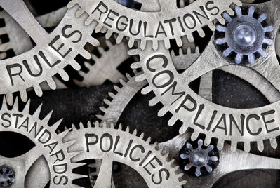 Cogs interlinked with words on around compliance