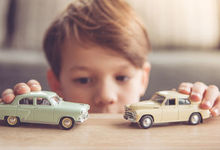 Boy playing with two cars