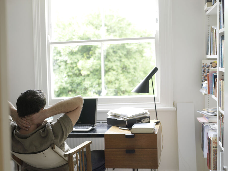 Man facing a window sat at a desk